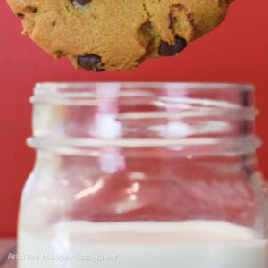 Chocolate chip cookie dunked in milk